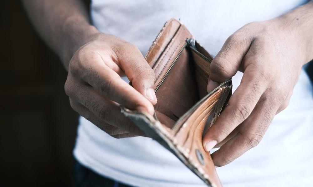 Person holding empty wallet because they could not afford their insurance deductible.